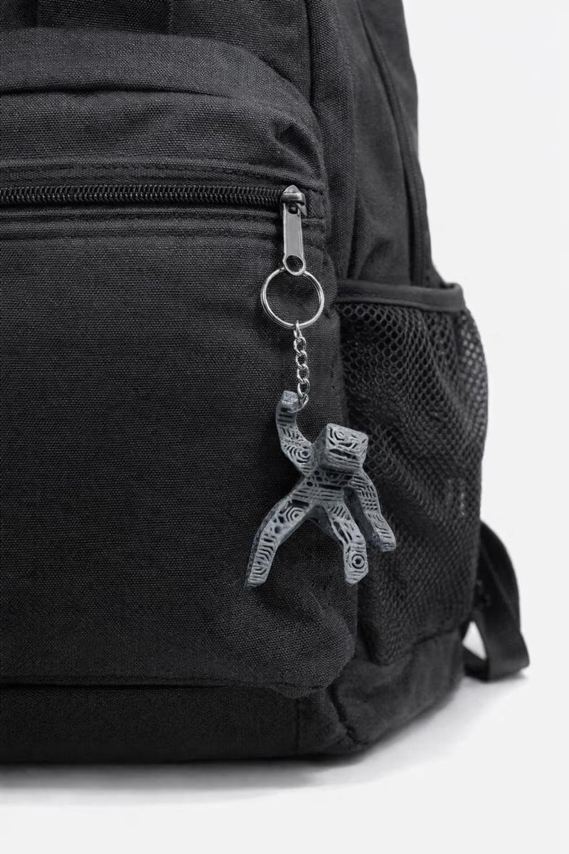 Black backpack with a keychain attached on a white background