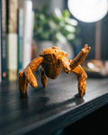 Wooden crab figurine on a dark surface with books and plants in the background